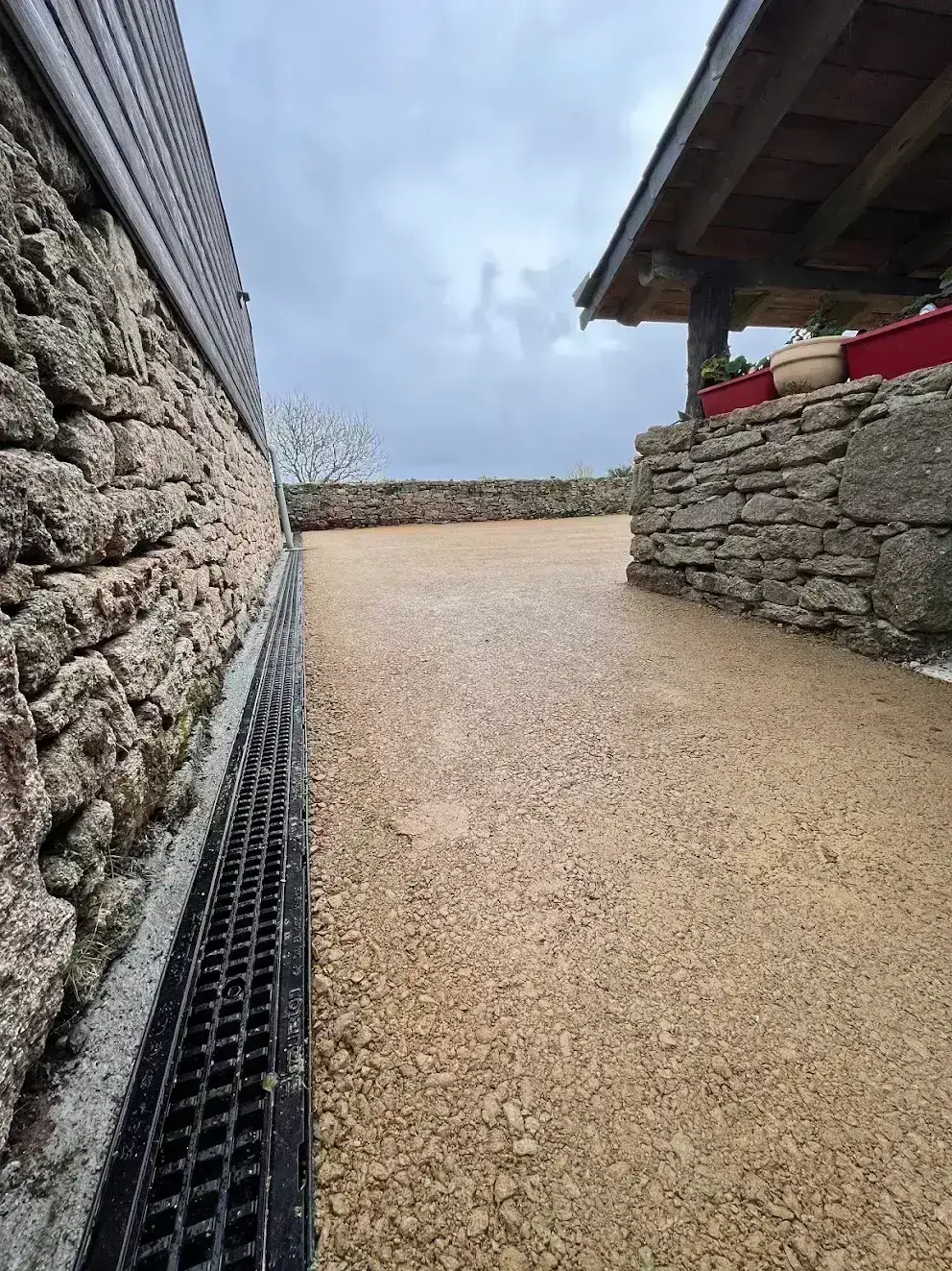Cour stabilisée avec caniveau drainant en bordure de mur, gestion des eaux pluviales en Finistère Sud