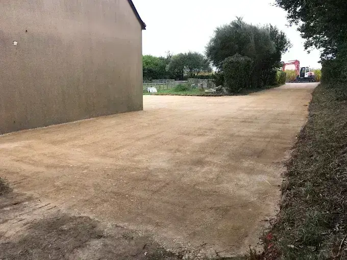 Cour d'accès en grave compactée le long d'un bâtiment, empierrement en Finistère Sud
