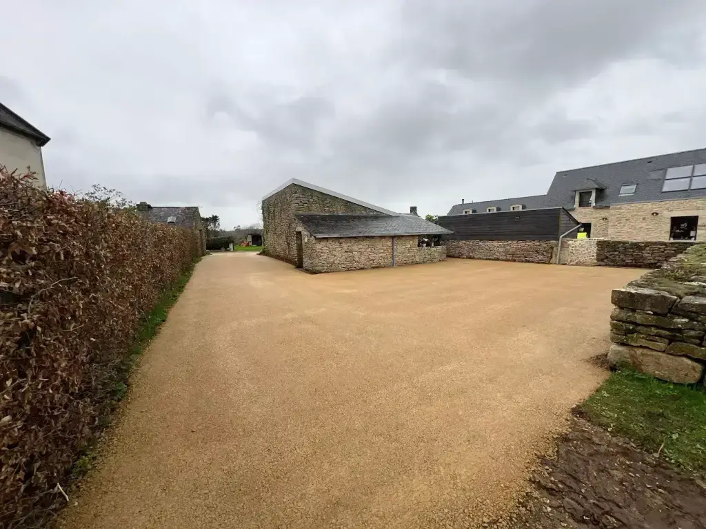 Cour en grave stabilisée devant une maison en pierre, empierrement en Finistère Sud