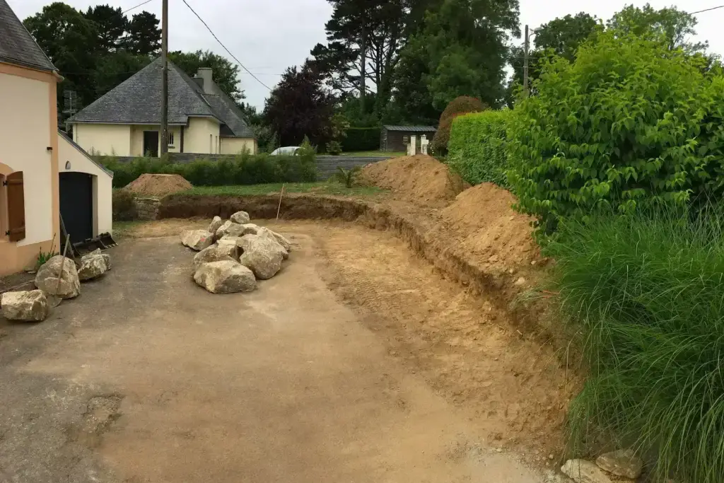 Blocs d'enrochement en attente et terrassement du talus à soutenir, soutènement en Finistère Sud