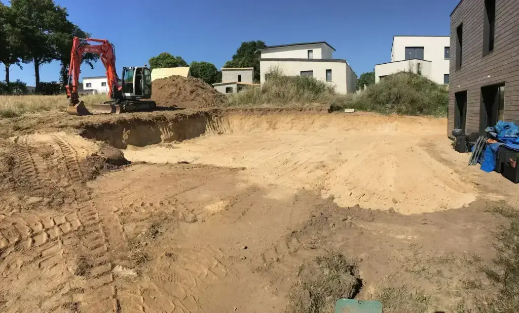 Terrassement d'un bassin avant pose d'enrochement à la pelle Kubota, aménagement en Finistère Sud
