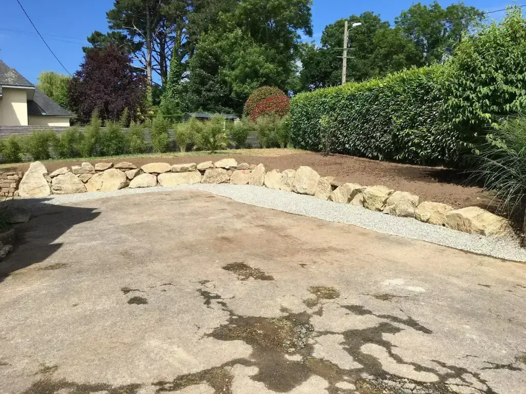 Muret d'enrochement fini bordé d'une allée en gravier, aménagement paysager en Finistère Sud