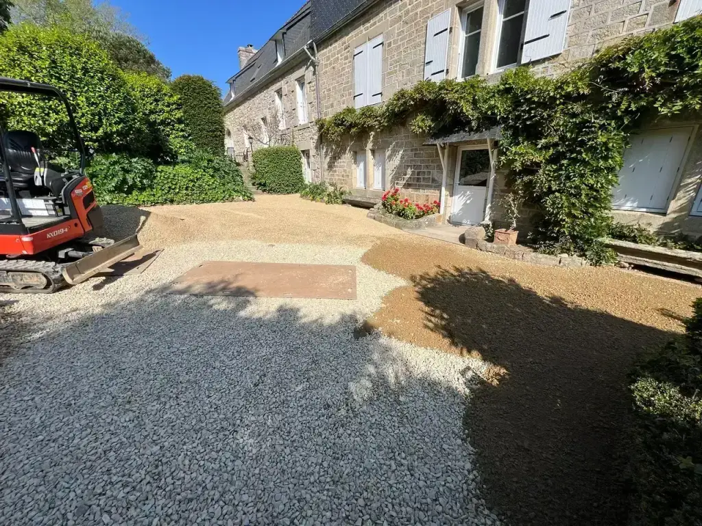 Régalage du gravier 0/20 à la mini-pelle pour la cour en stabilisé d'un Airbnb à Douarnenez